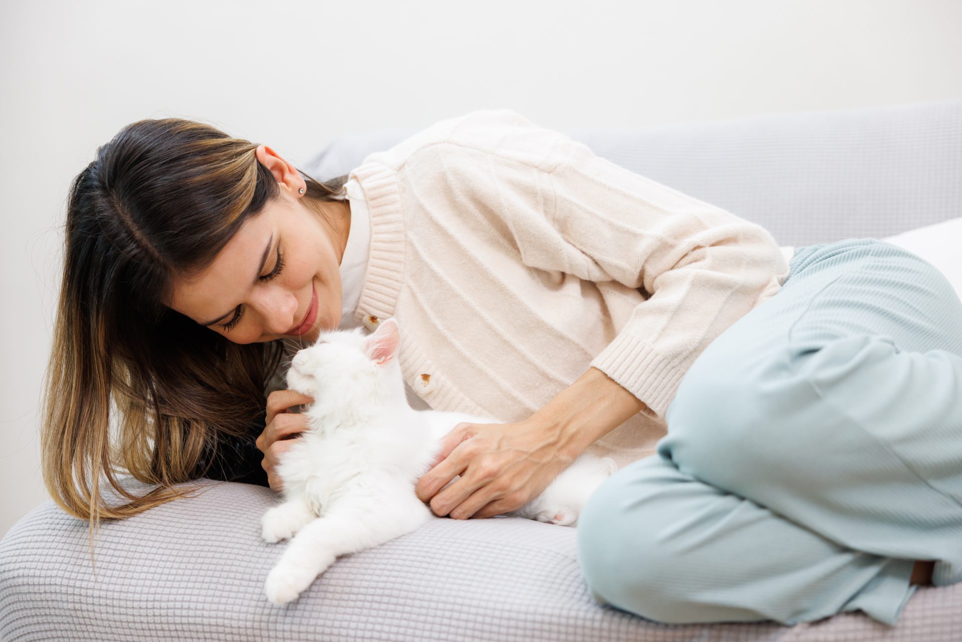 giovane donna accarezza gatto bianco
