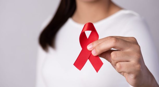 giornata-mondiale-aids_cover donna tiene in mano fiocco simbolo della lotta all'aids