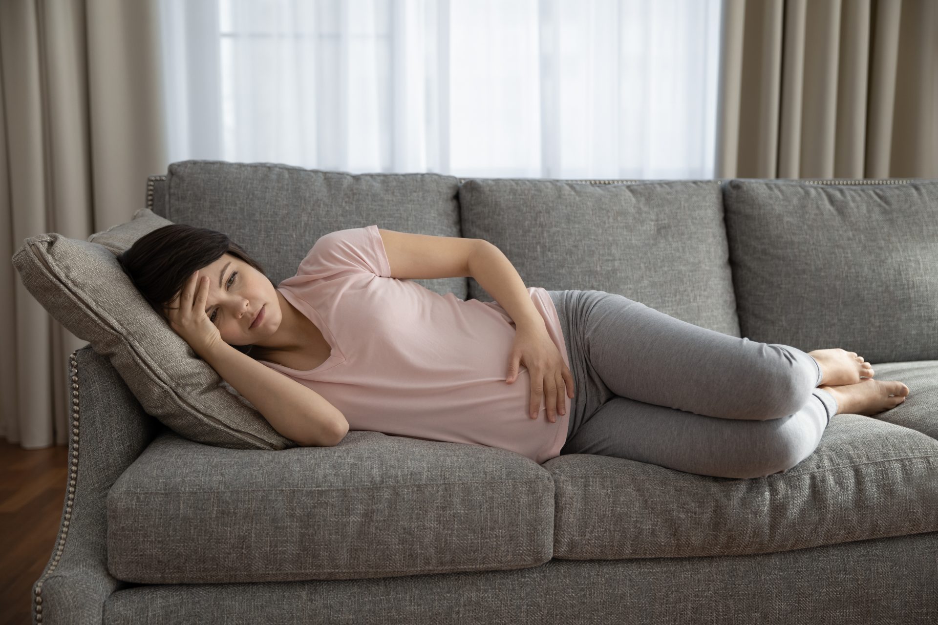donna incinta distesa sul divano con malessere