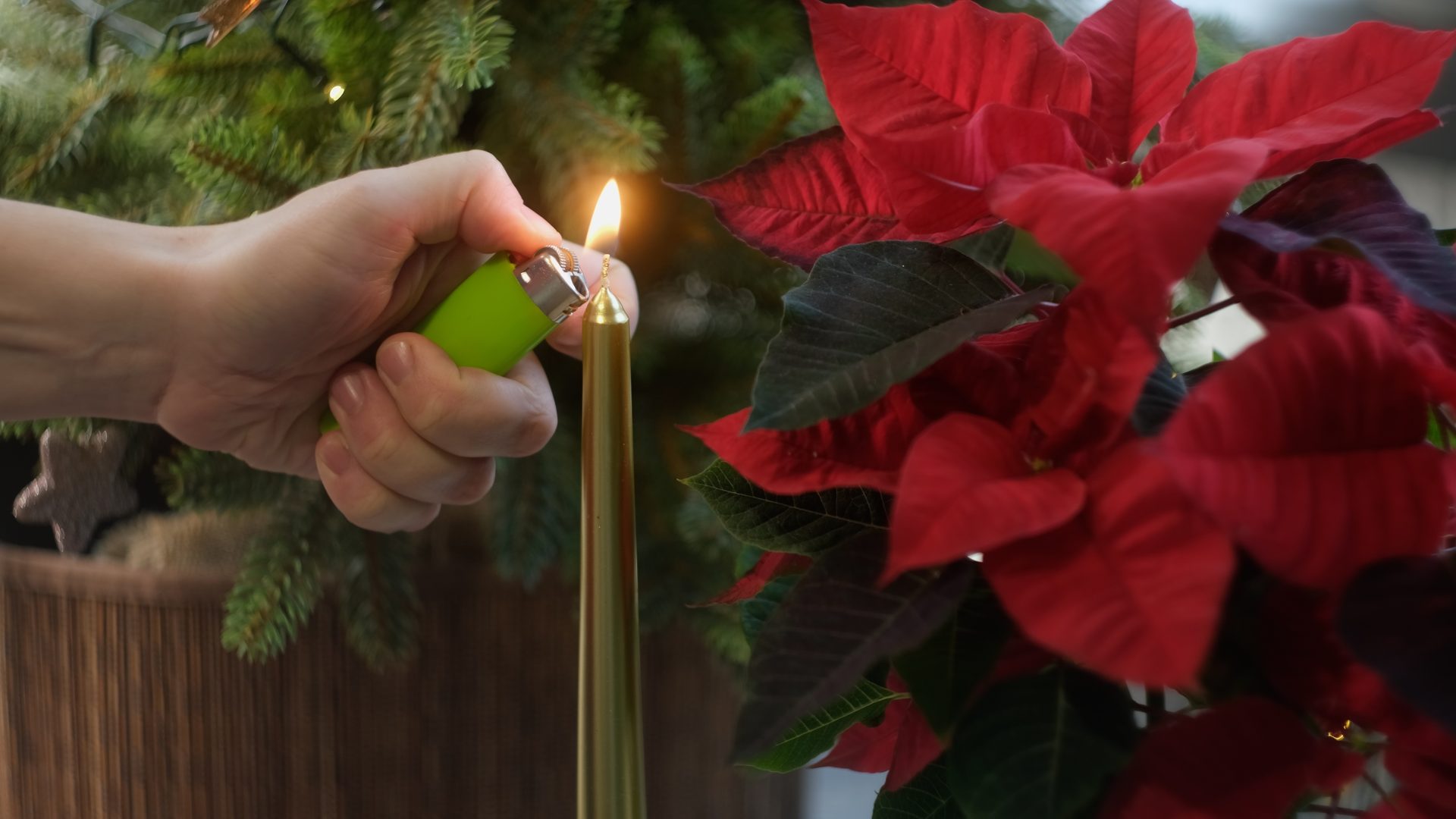 mano accende candela vicino a stella di natale