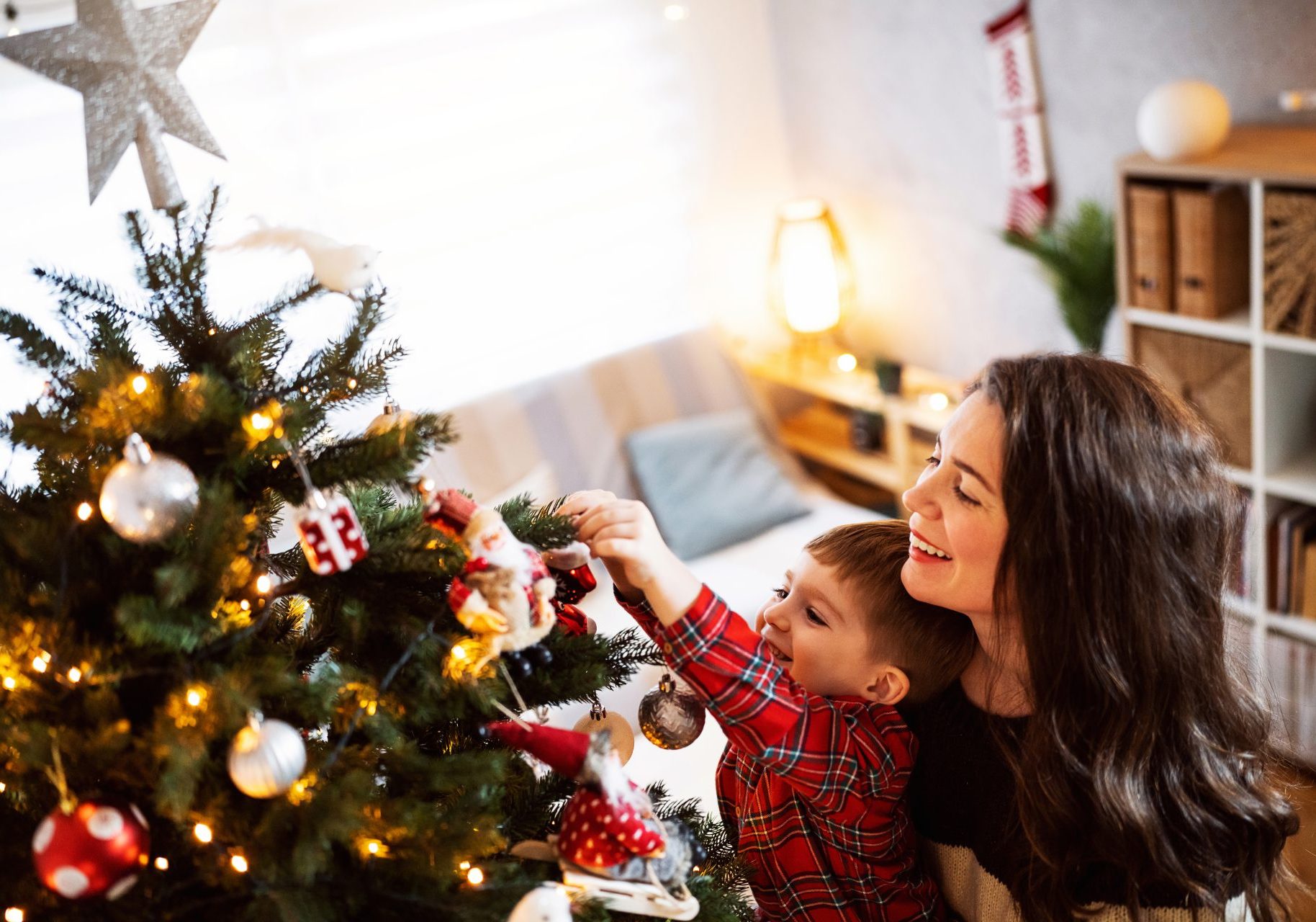 madre e figlio piccolo decorano albero di natale