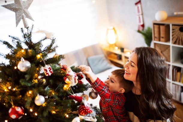 madre e figlio piccolo decorano albero di natale