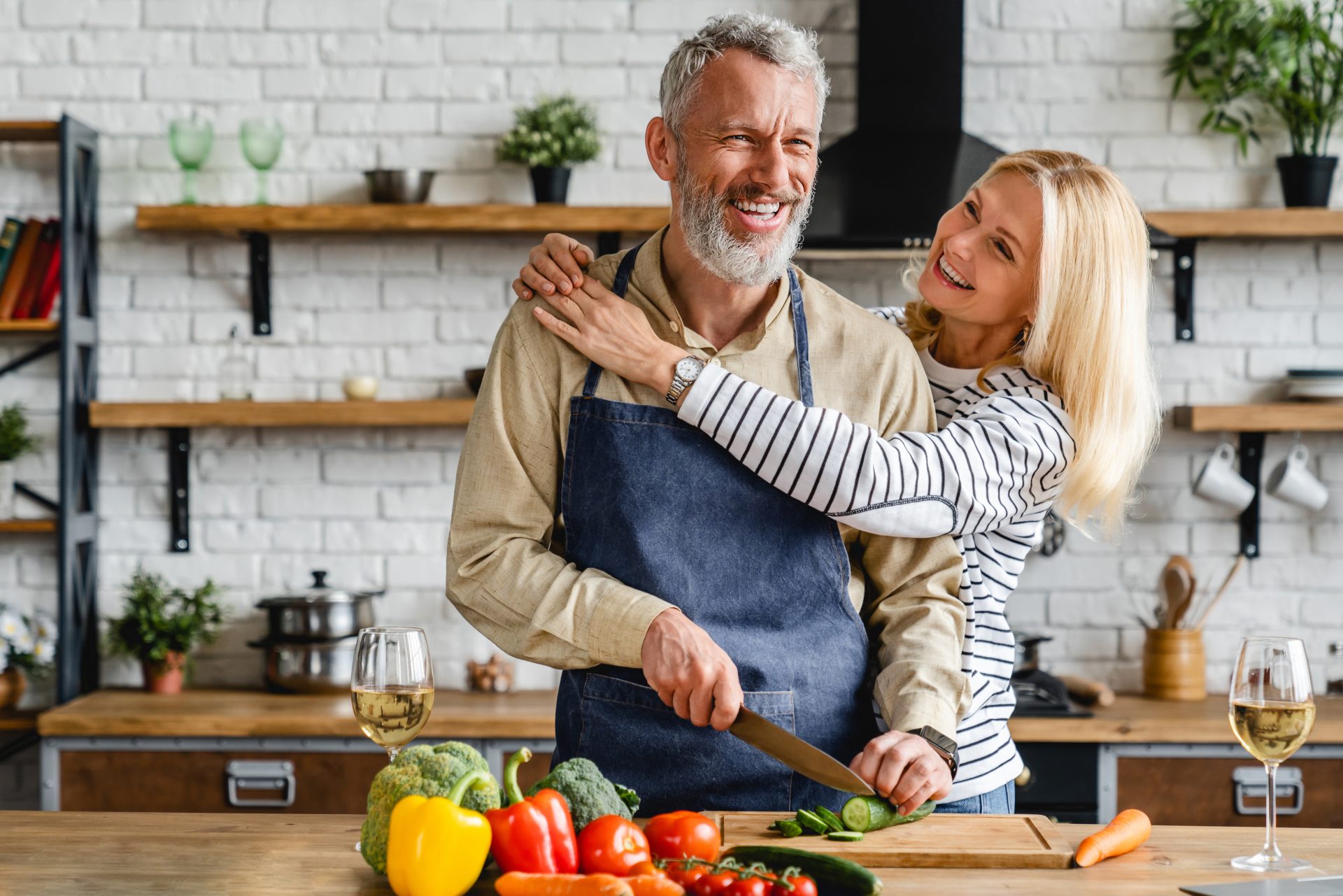 uomo e donna di mezza età contenti in cucina