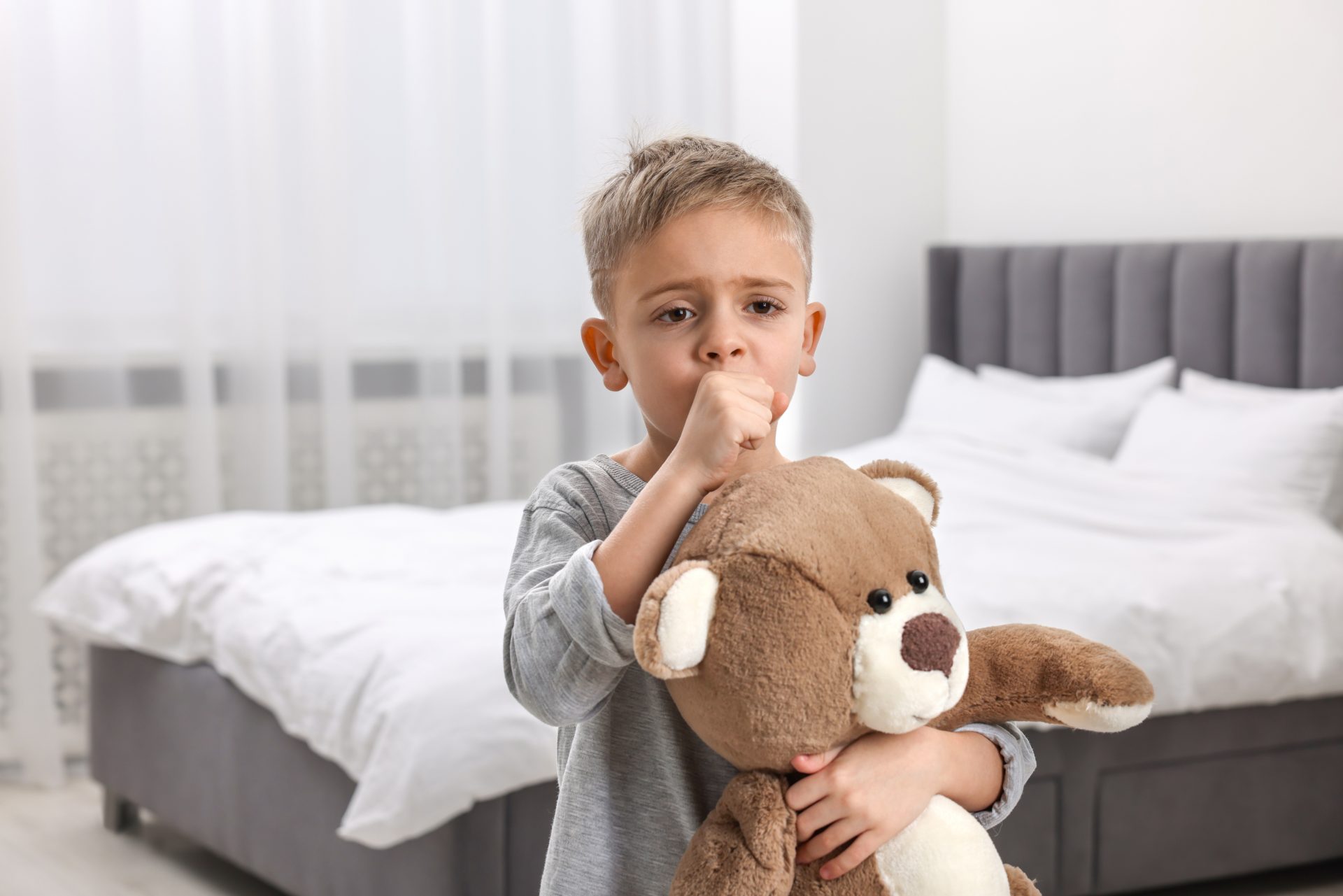 bambino piccolo con peluche tossisce