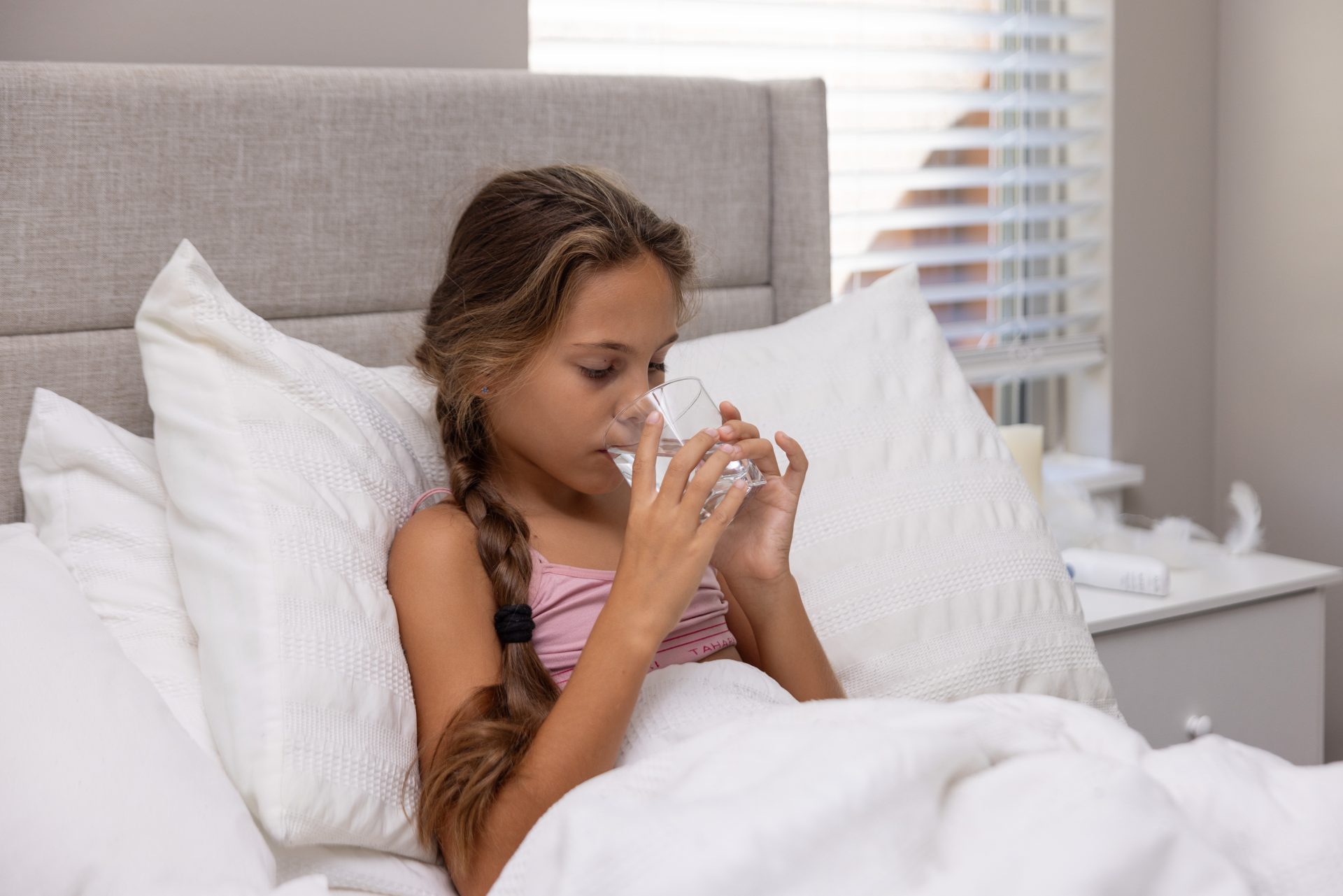 bambina a letto beve acqua da bicchiere