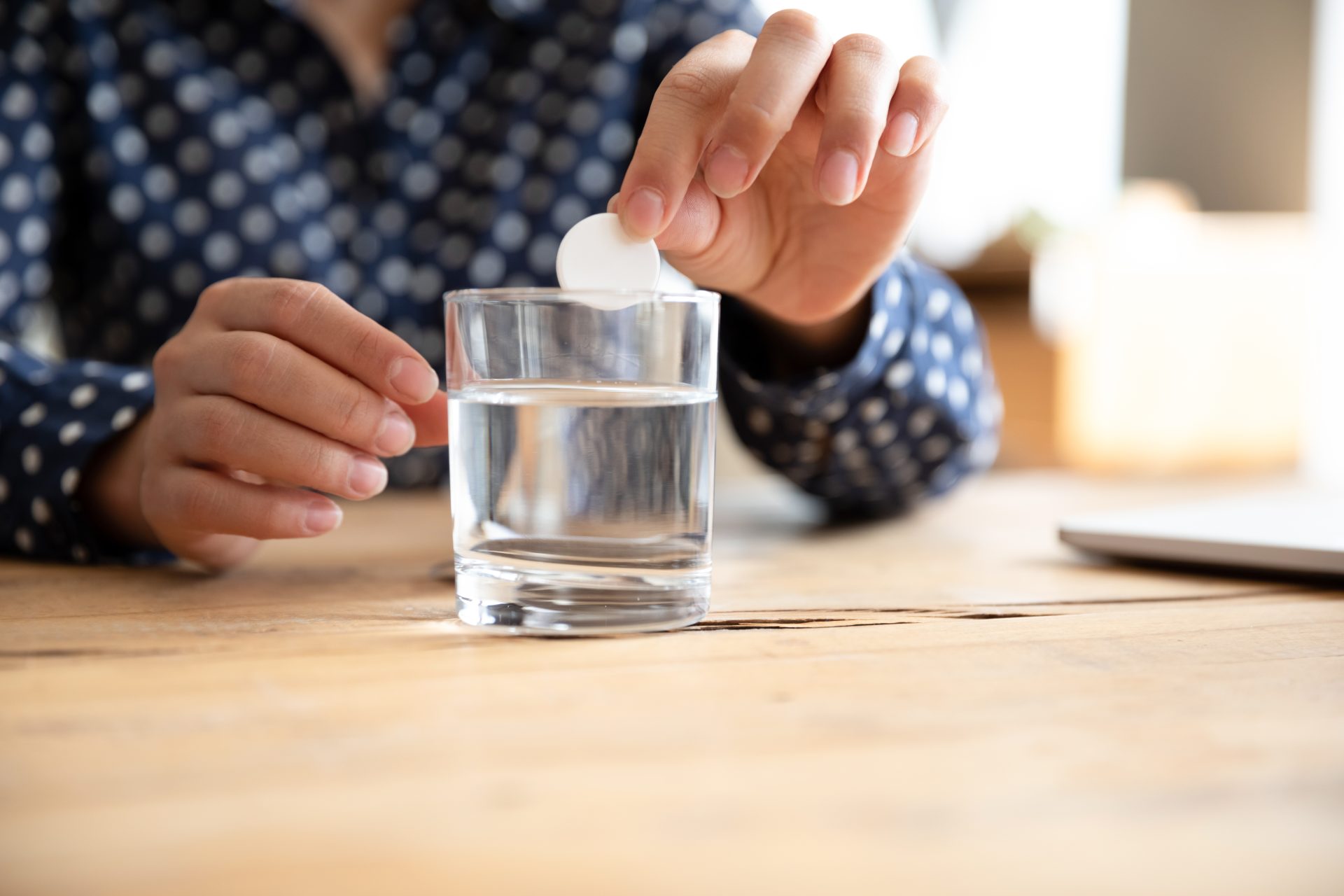 persona assume farmaco antiacido con bicchiere d'acqua