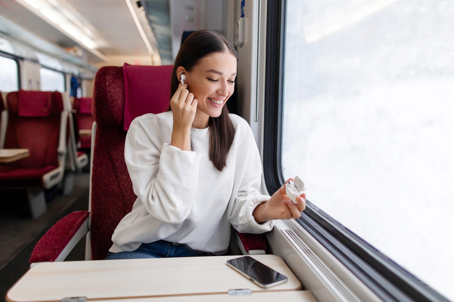 giovane donna con auricolari in treno