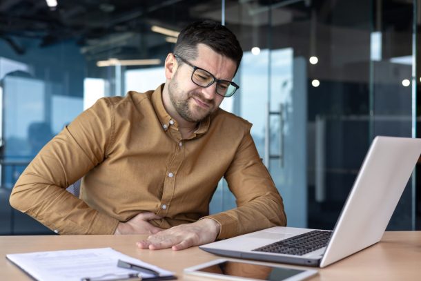 uomo con mal di stomaco a lavoro