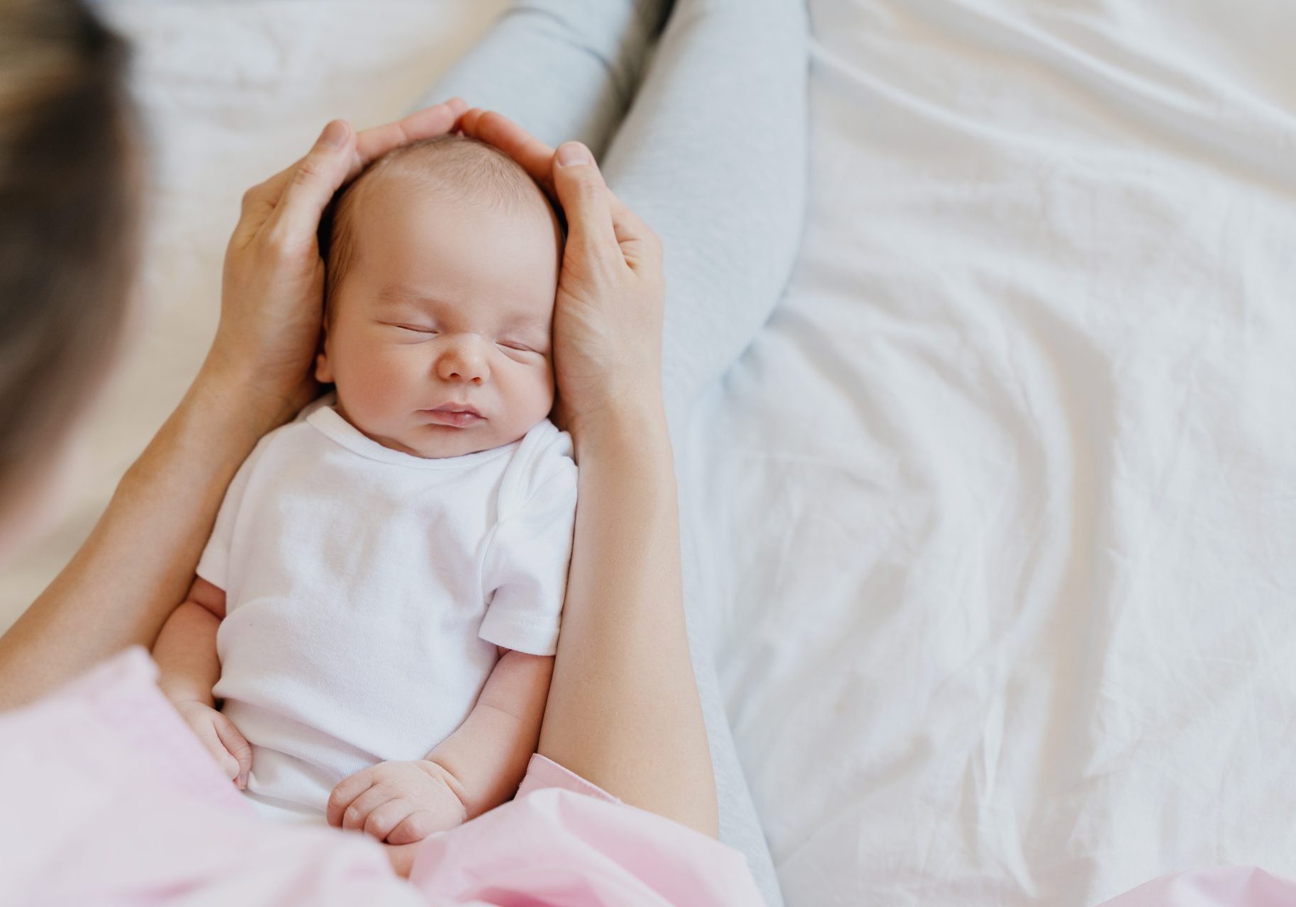 neonato dorme in braccio alla mamma