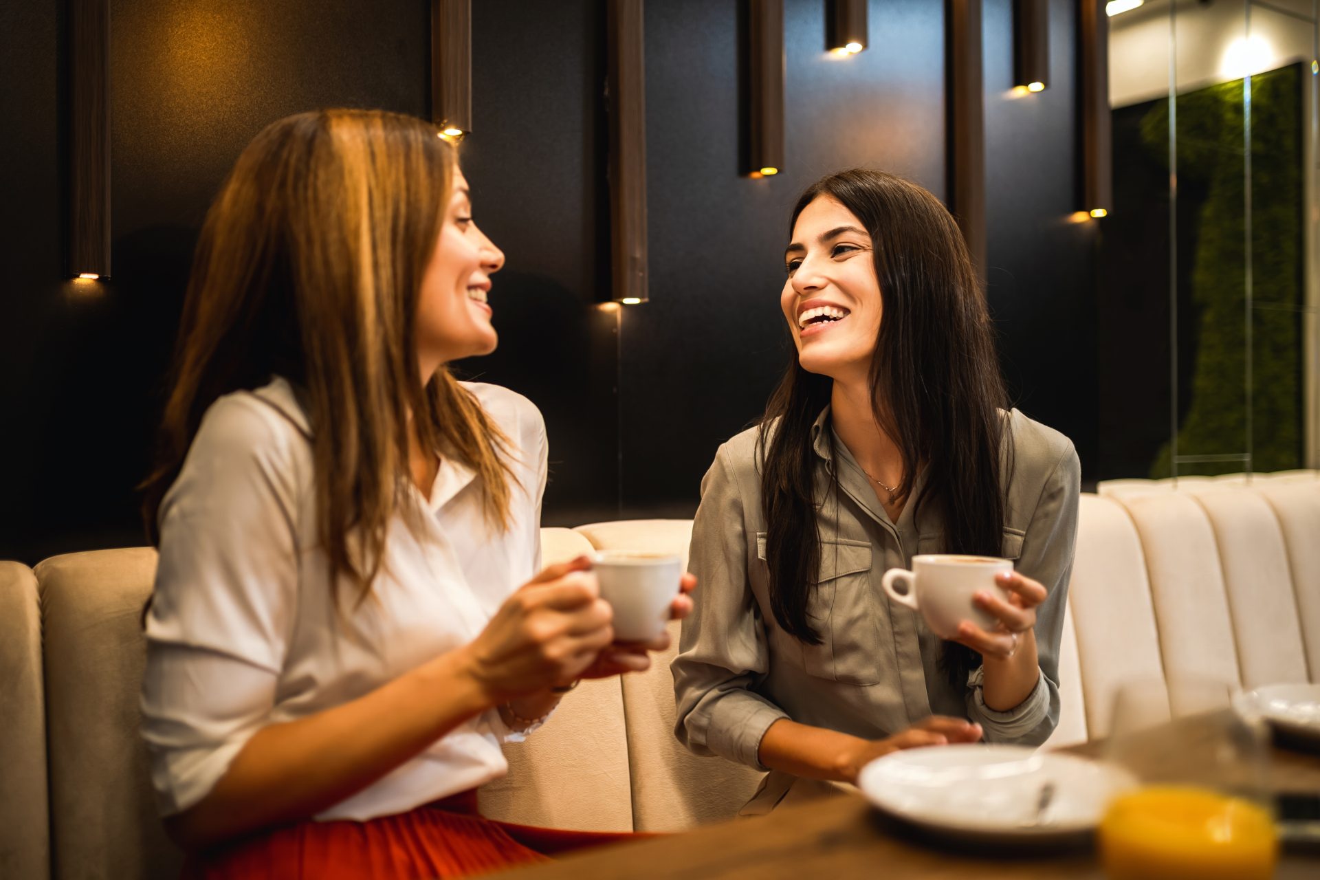 due donne parlano bevendo caffè