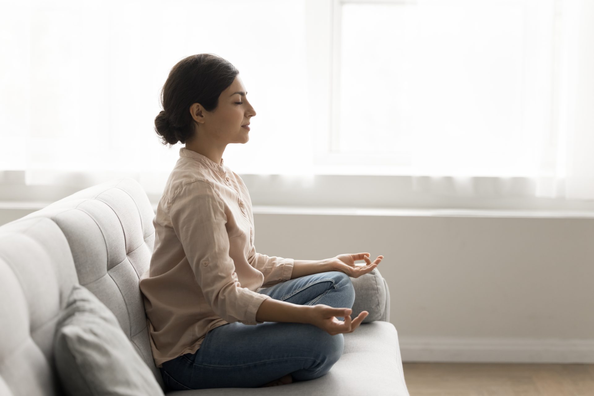 giovane donna fa meditazione sul divano