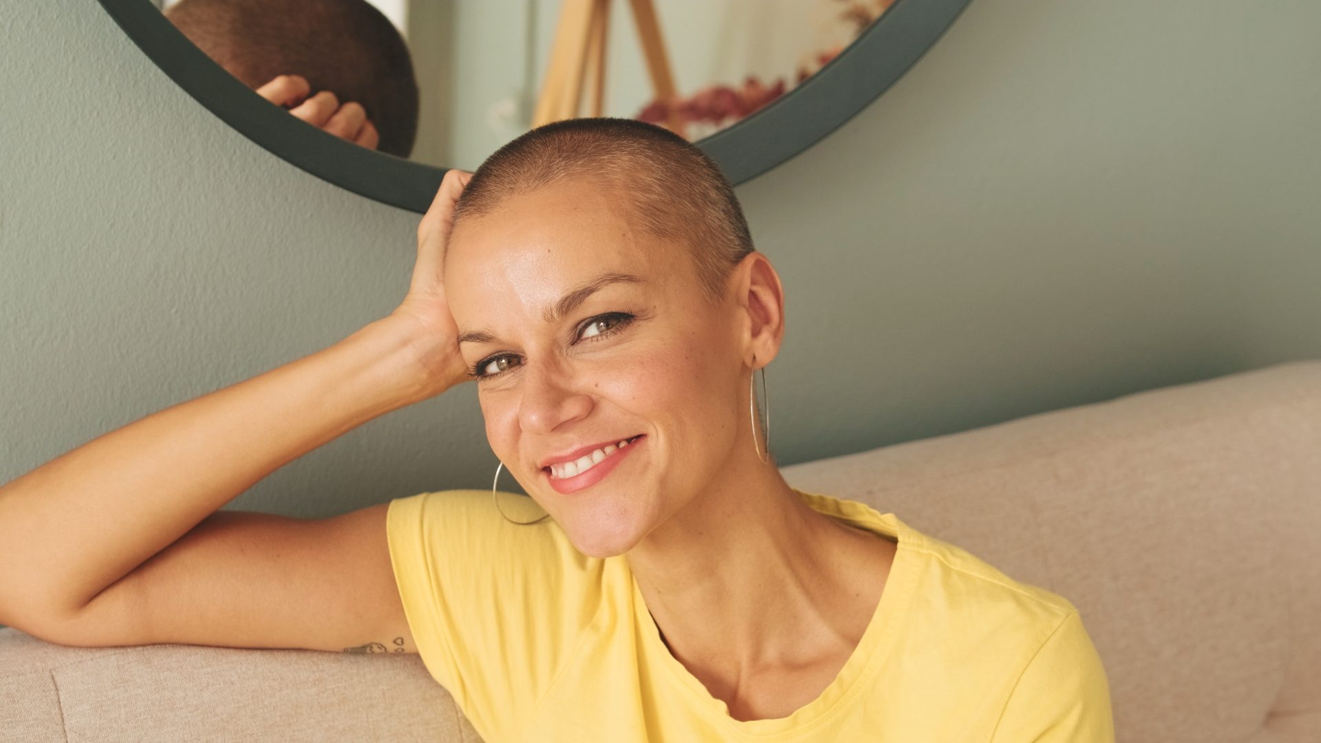 donna sorridente con capelli rasati