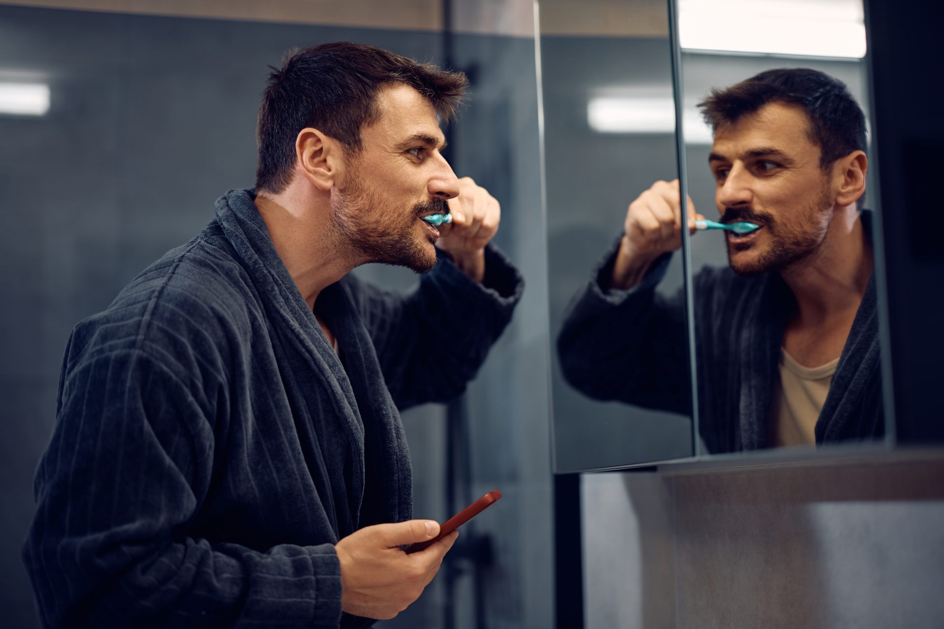 uomo lava i denti allo specchio