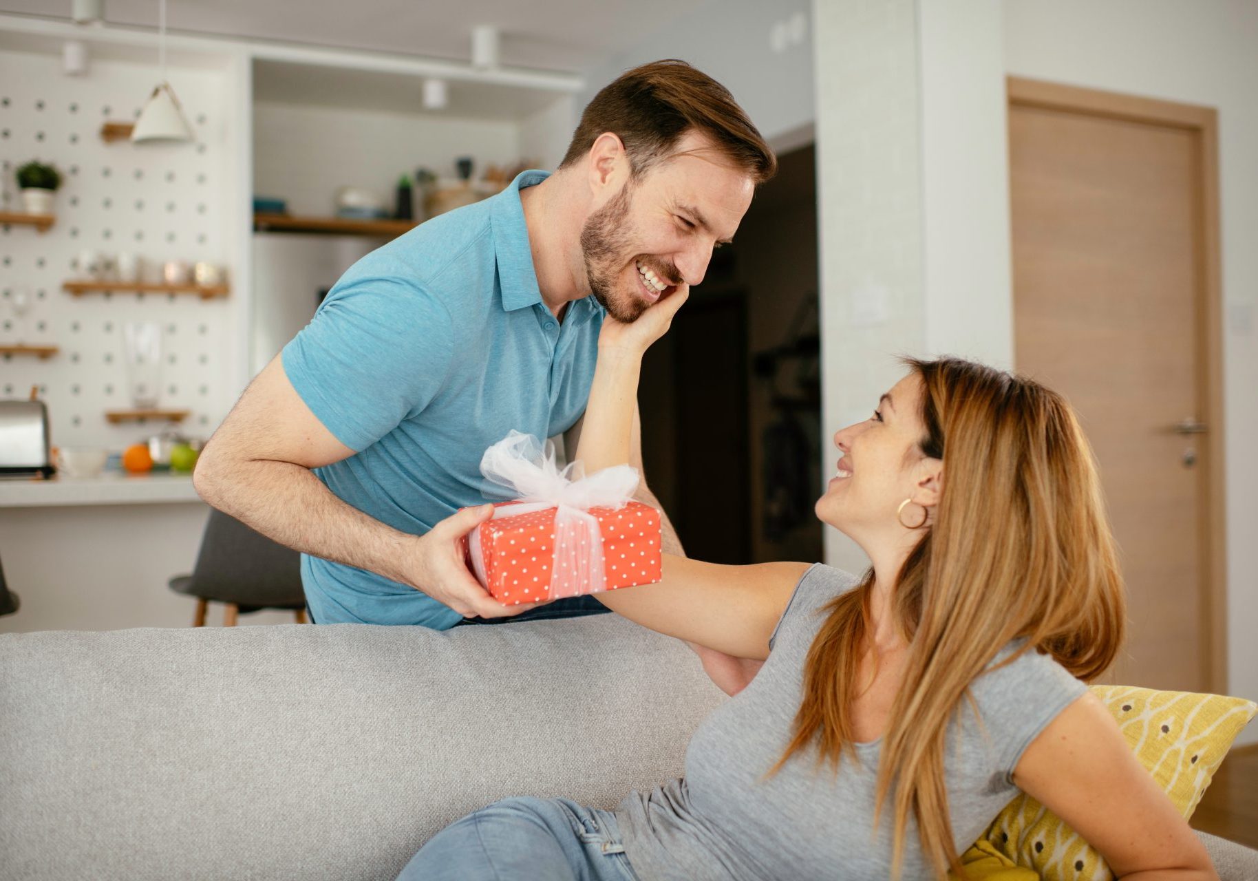 uomo dà pacco regalo alla compagna