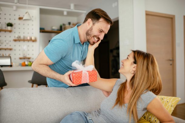 uomo dà pacco regalo alla compagna