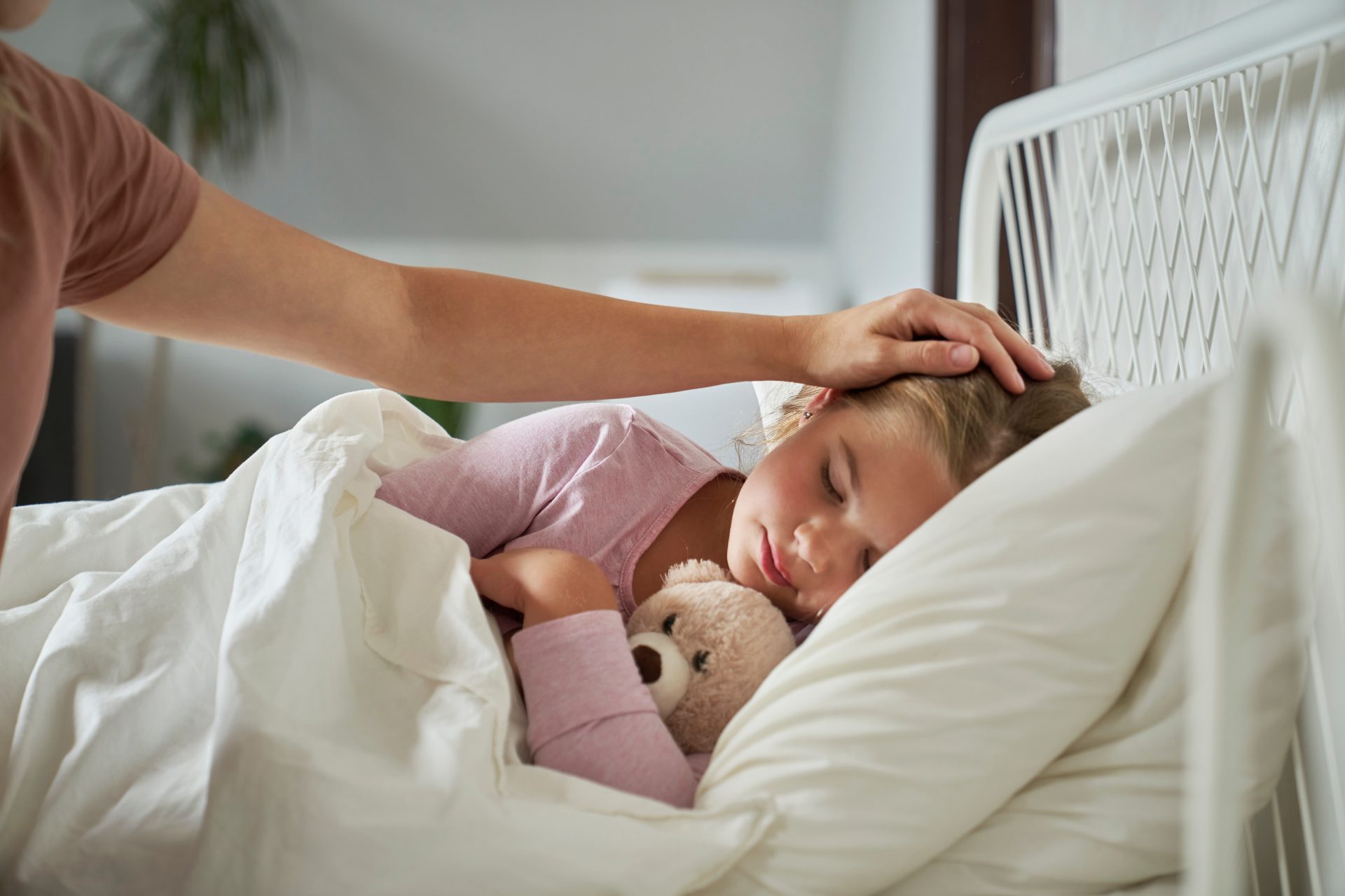 madre accudisce bambina a letto