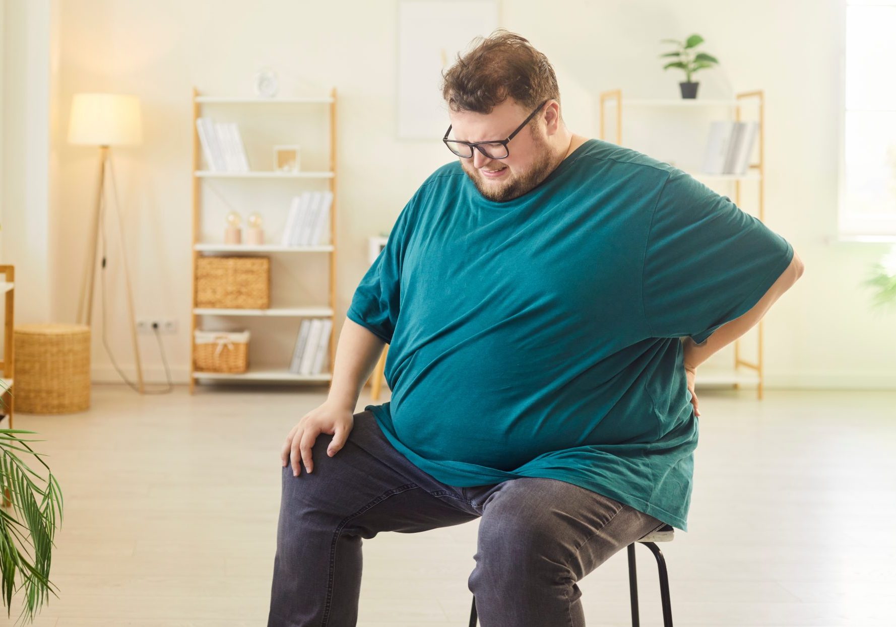 uomo obeso seduto su sgabello