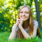 giovane ragazza sorridente distesa su prato