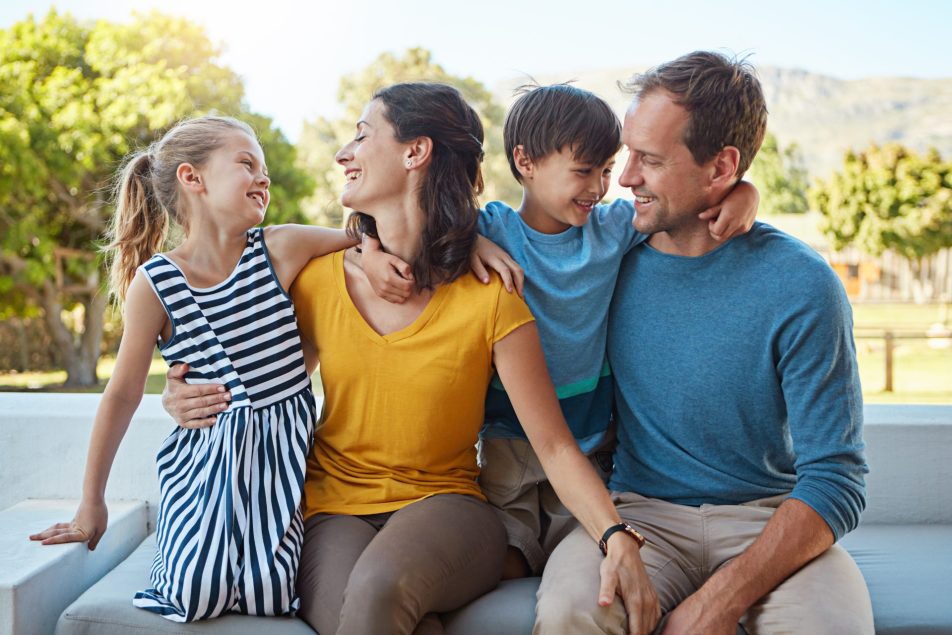famiglia di madre, padre, bambino e bambina abbracciati