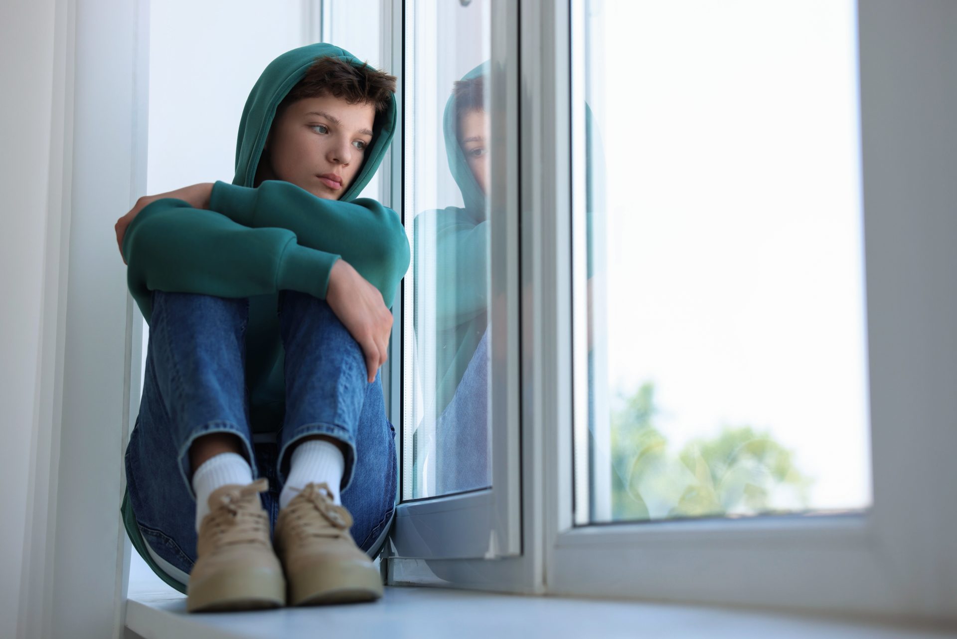 ragazzo solitario guarda fuori dalla finestra