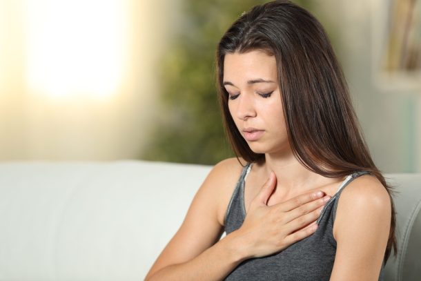 giovane donna con mano sul torace per tachicardia
