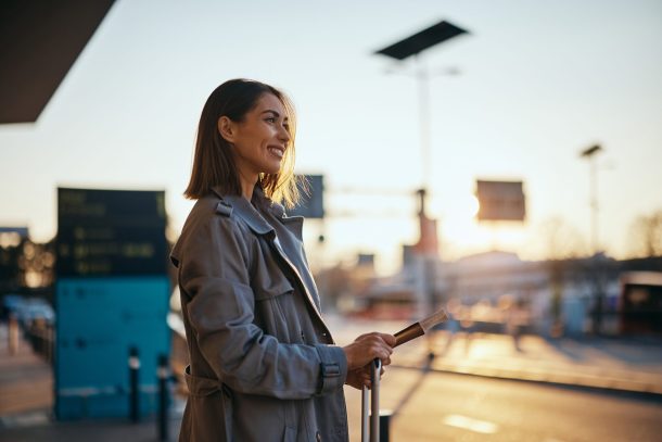 assicurazione-viaggio-breve_cover donna sorridente in aeroporto