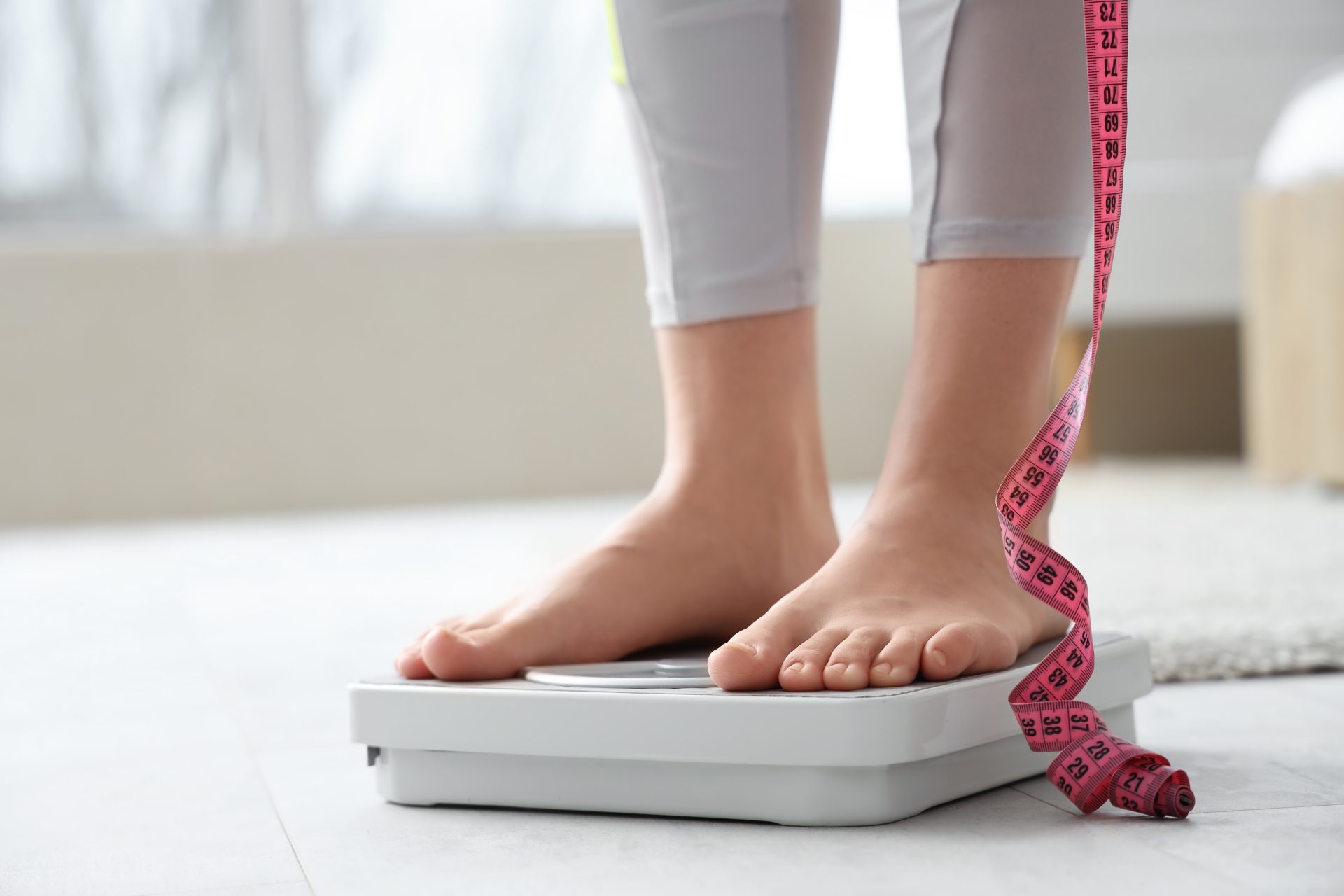 piedi di una donna sulla bilancia con metro
