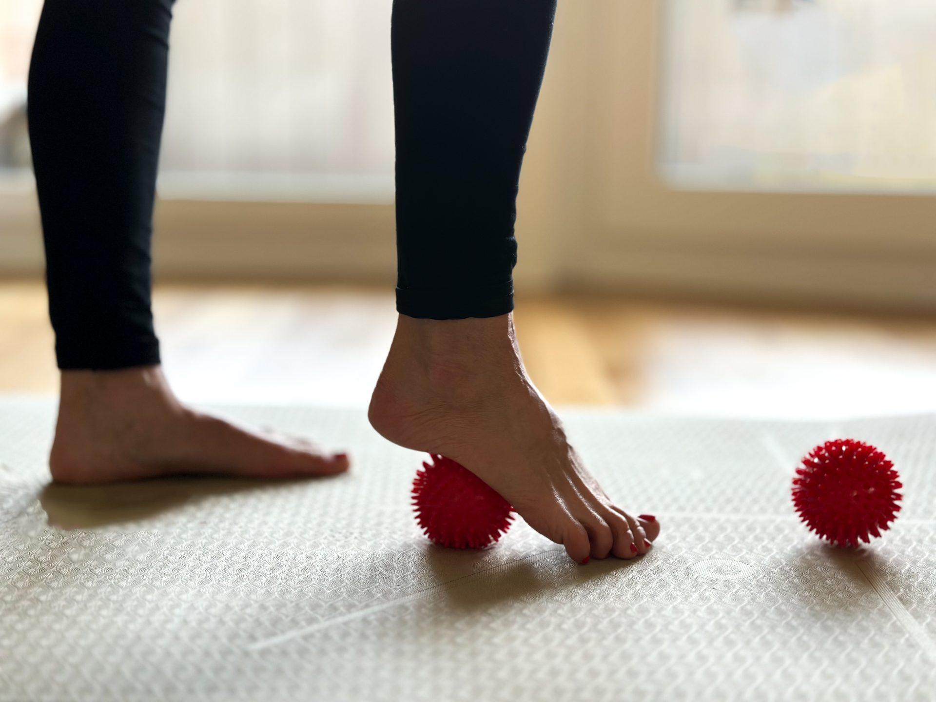 donna fa esercizi per gambe con pallina sotto il piede