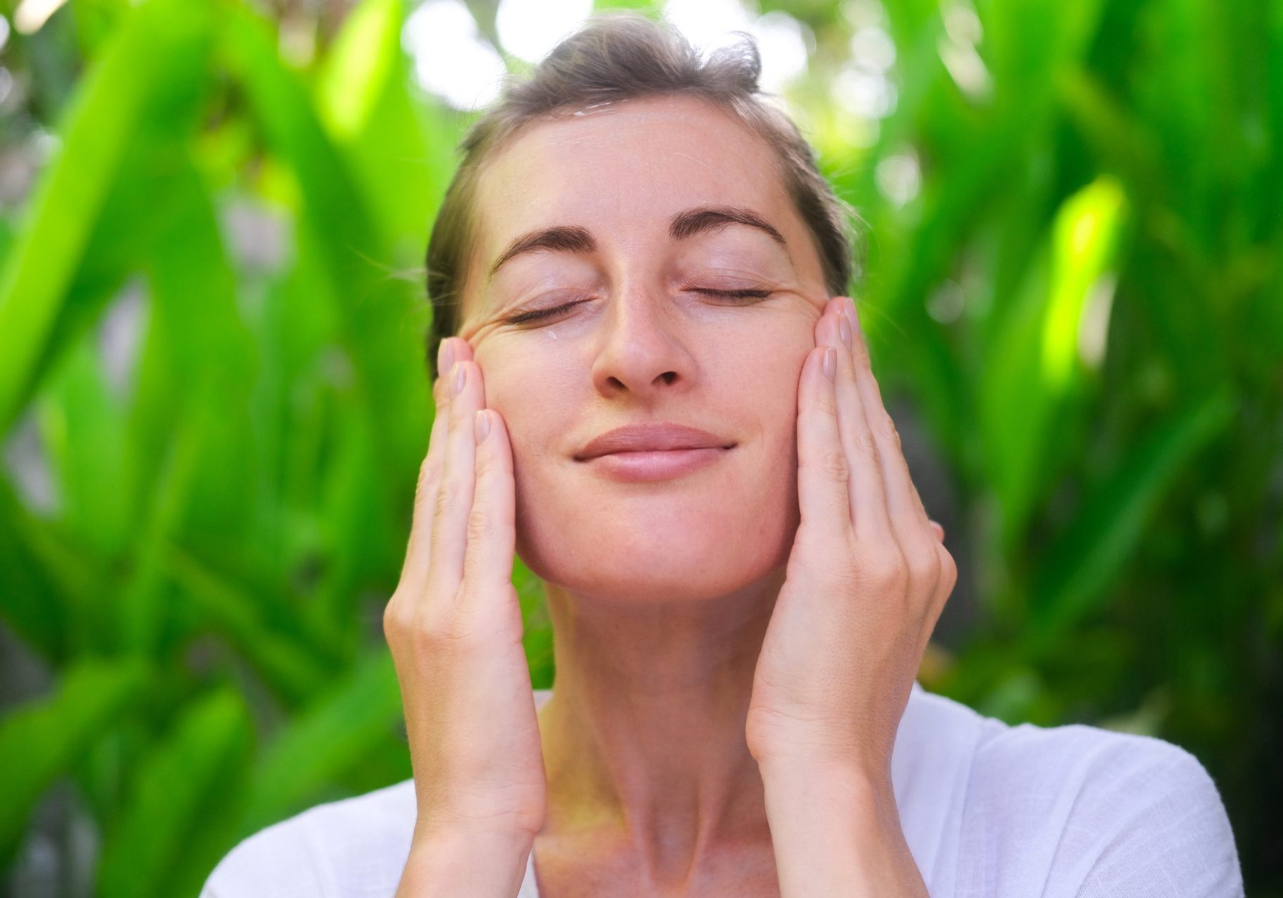 donna si tocca il viso all'aperto