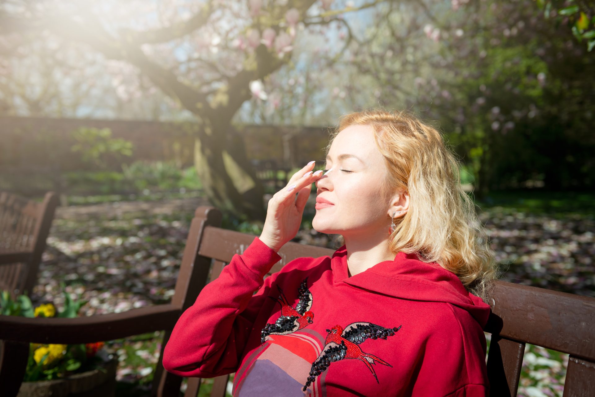 ragazza seduta su una panchina applica protezione solare