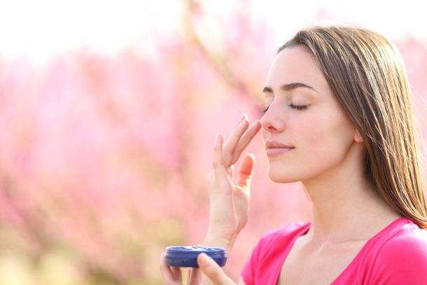 giovane donna applica protezione solare all'aperto