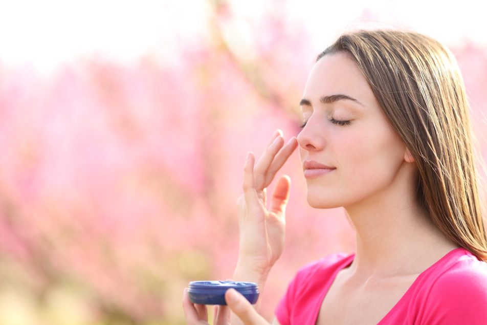 giovane donna applica protezione solare all'aperto