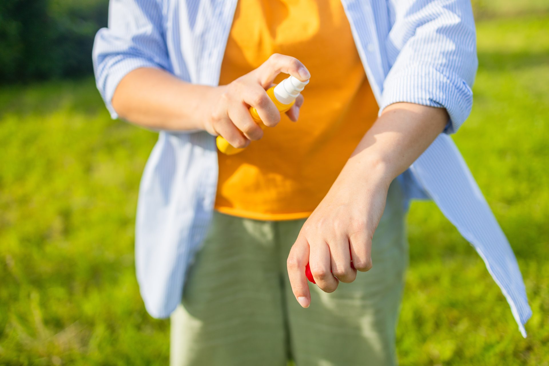 uomo applica spray repellente anti insetti