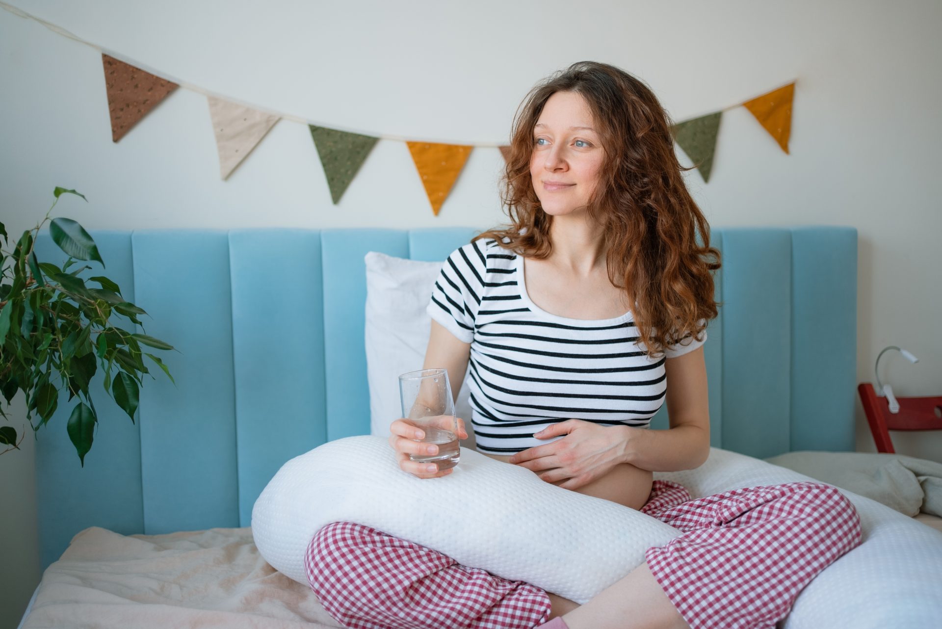 donna incinta seduta sul letto