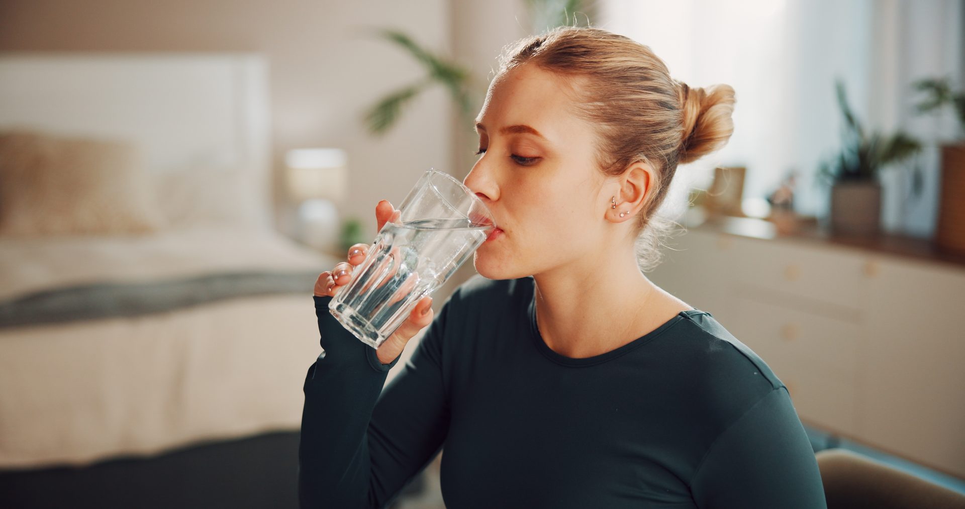 giovane donna beve bicchere d'acqua