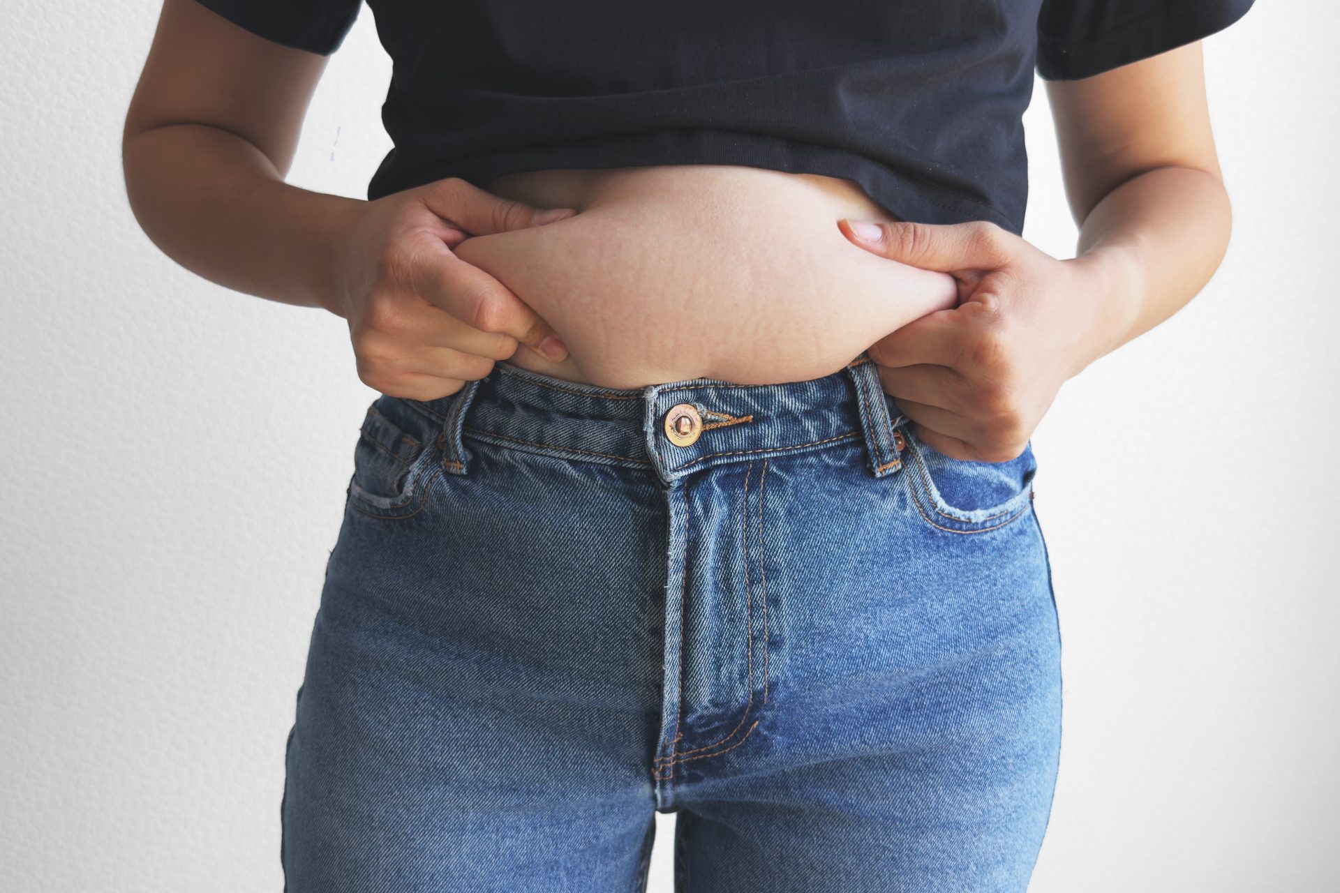 giovane donna in jeans si tocca la pancia