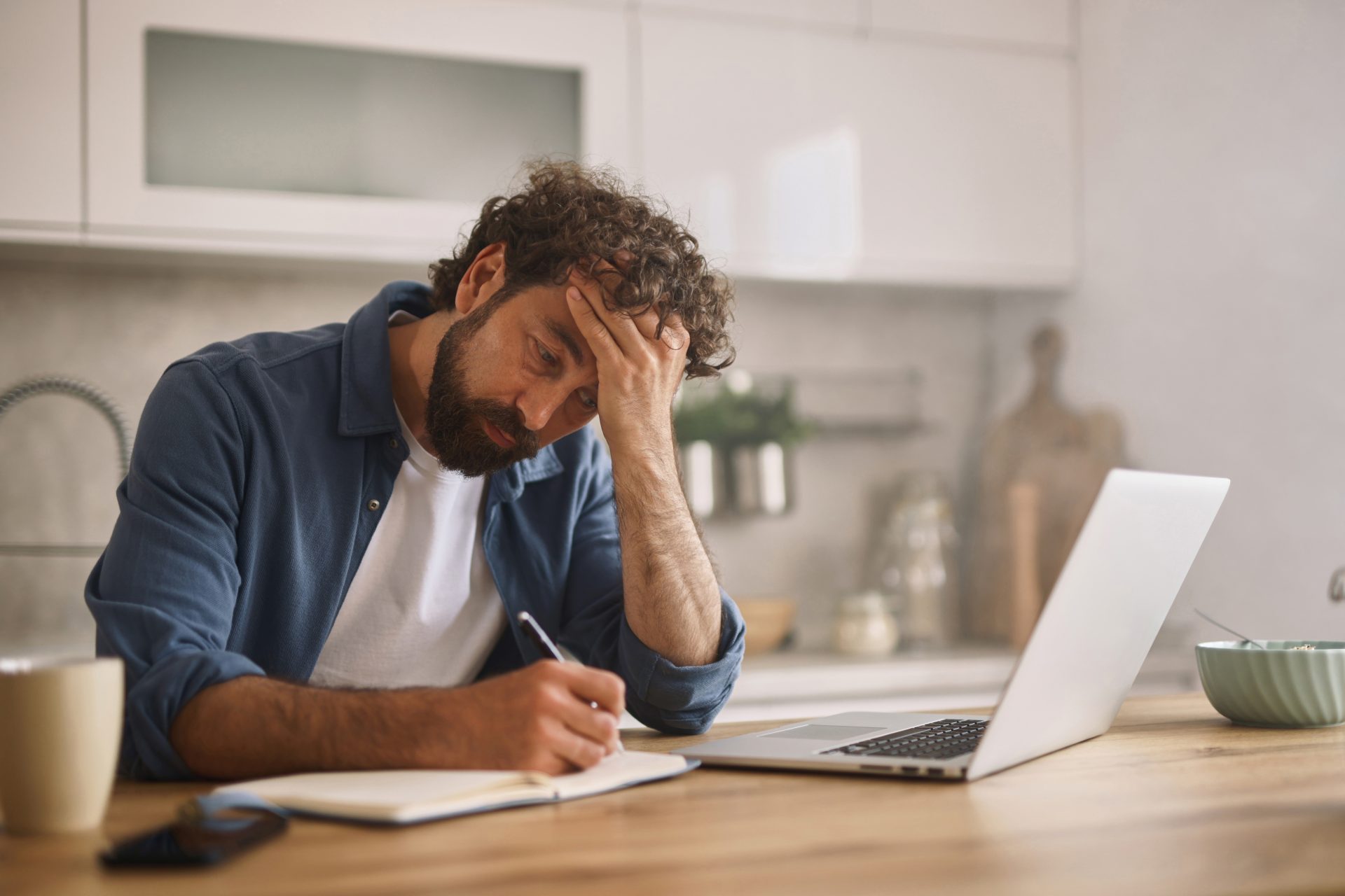 uomo stressato scrive su agenda