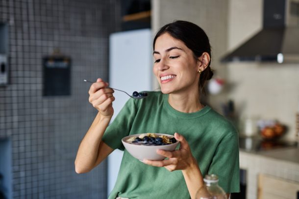 giovane donna mangia ciotola di porridge
