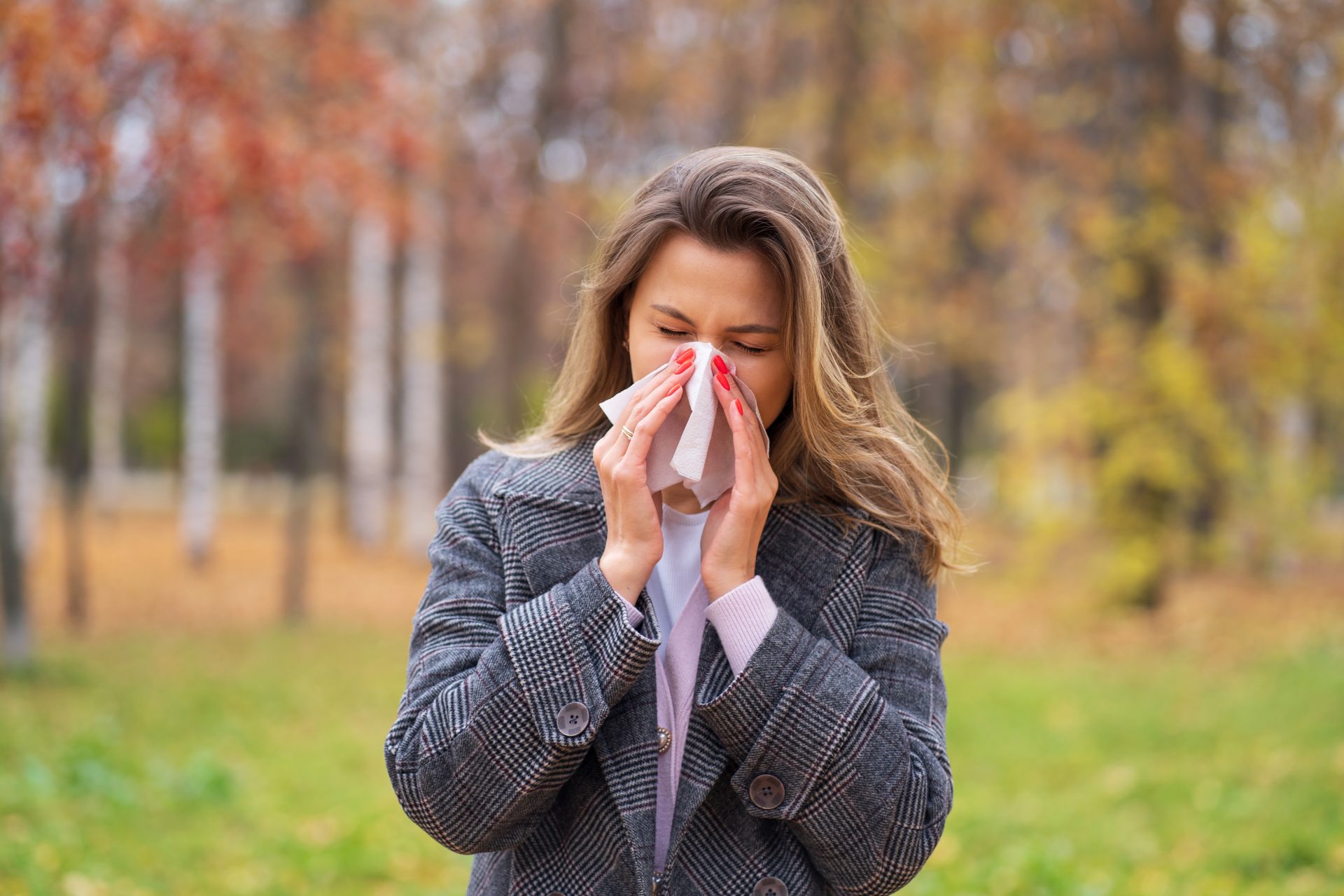 donna con rinite allergica si soffia il naso