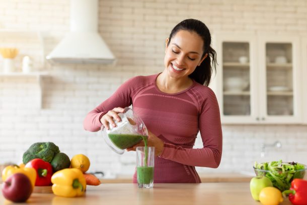 donna sportiva prepara frullato di frutta e verdura