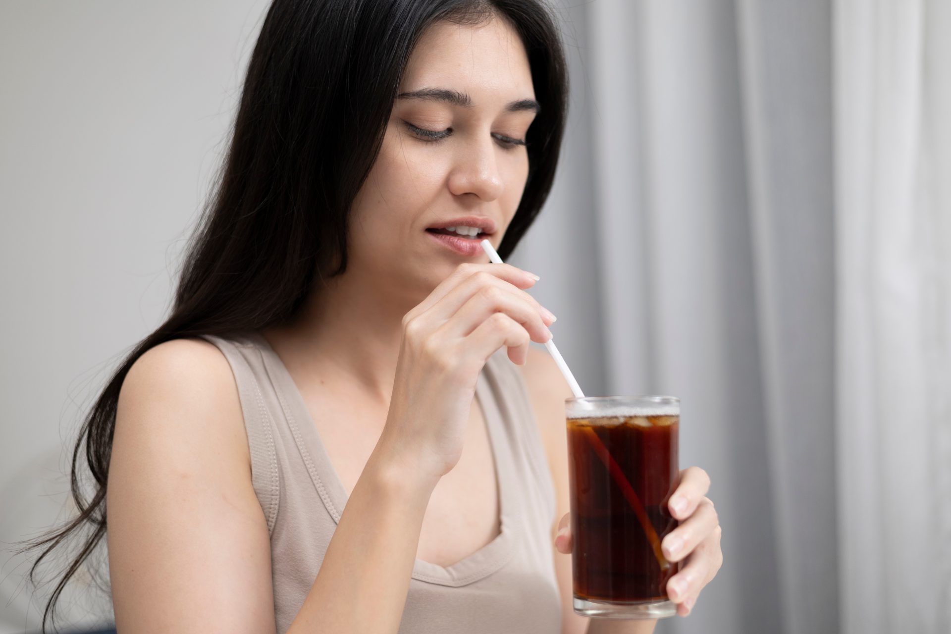 giovane donna beve bibita gassata