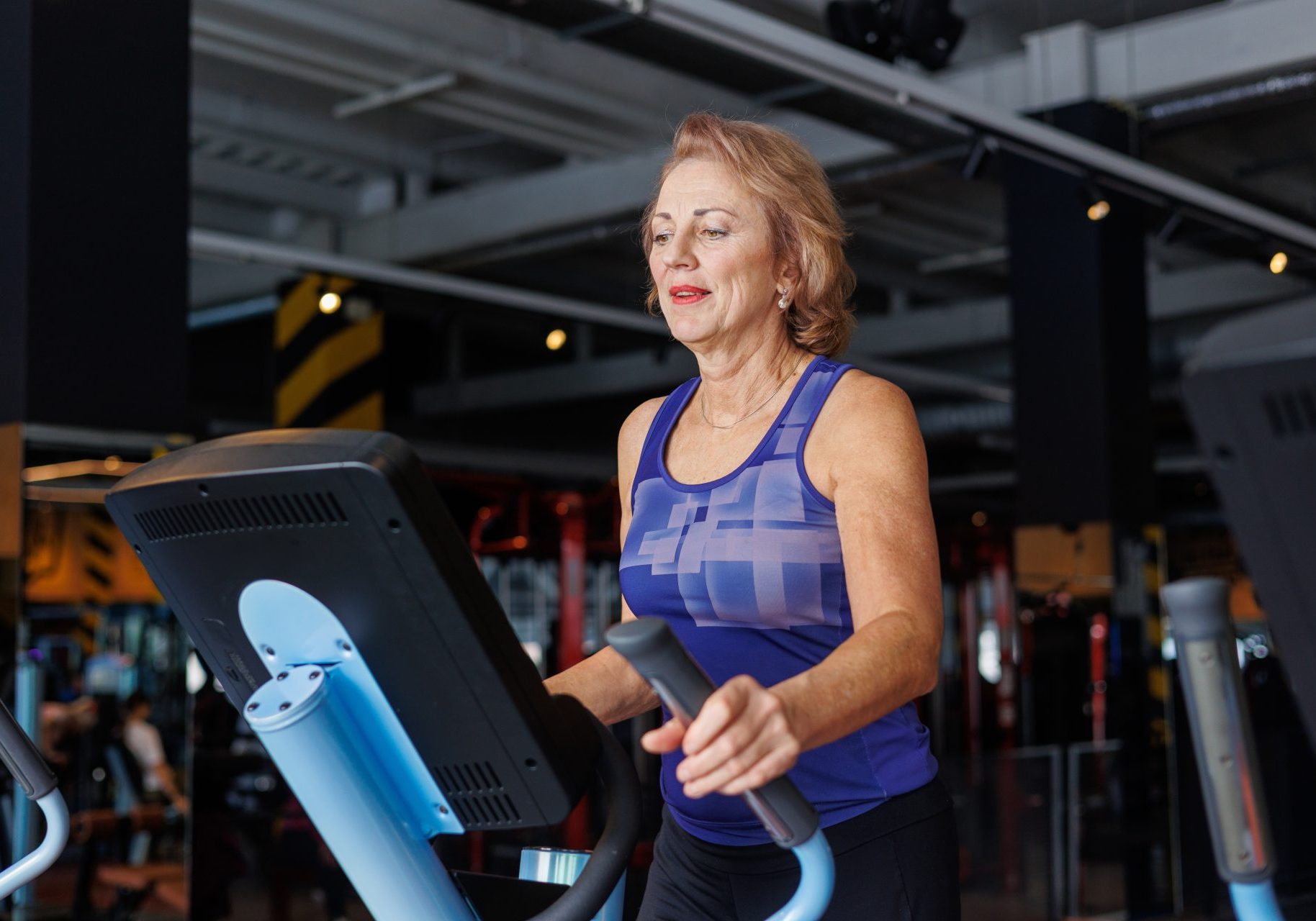 donna anziana su ellittica in palestra
