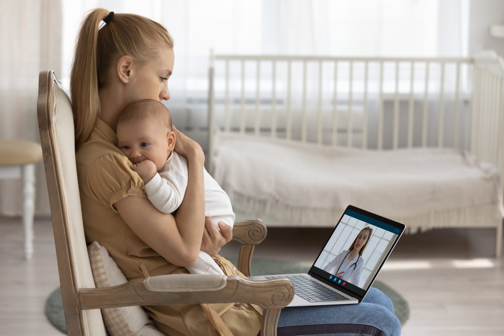 mamma con bambino in braccio in videochat con pediatra