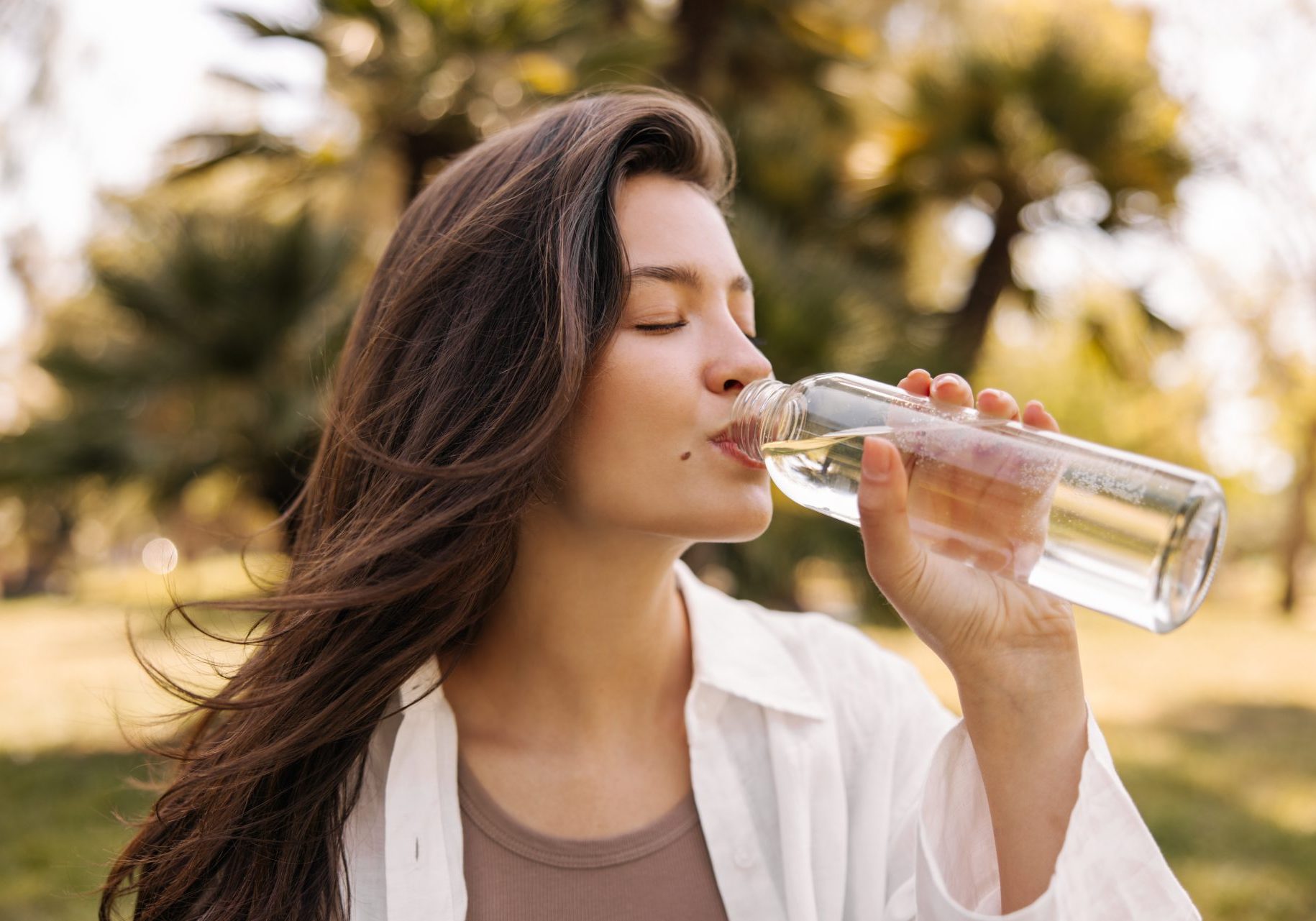 ritenzione-idrica giovane donna beve acqua all'aperto