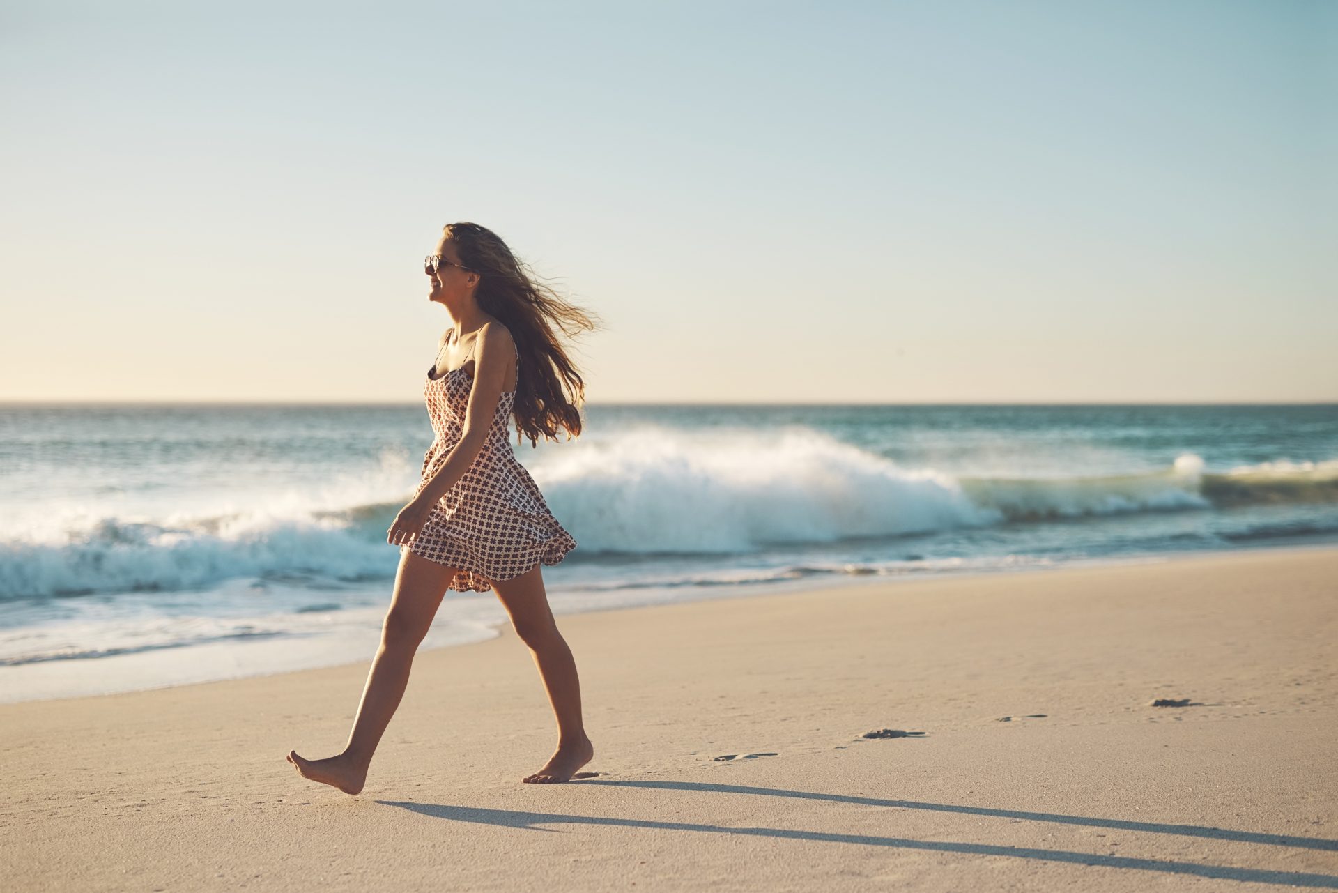 giovane donna cammina sulla spiaggia