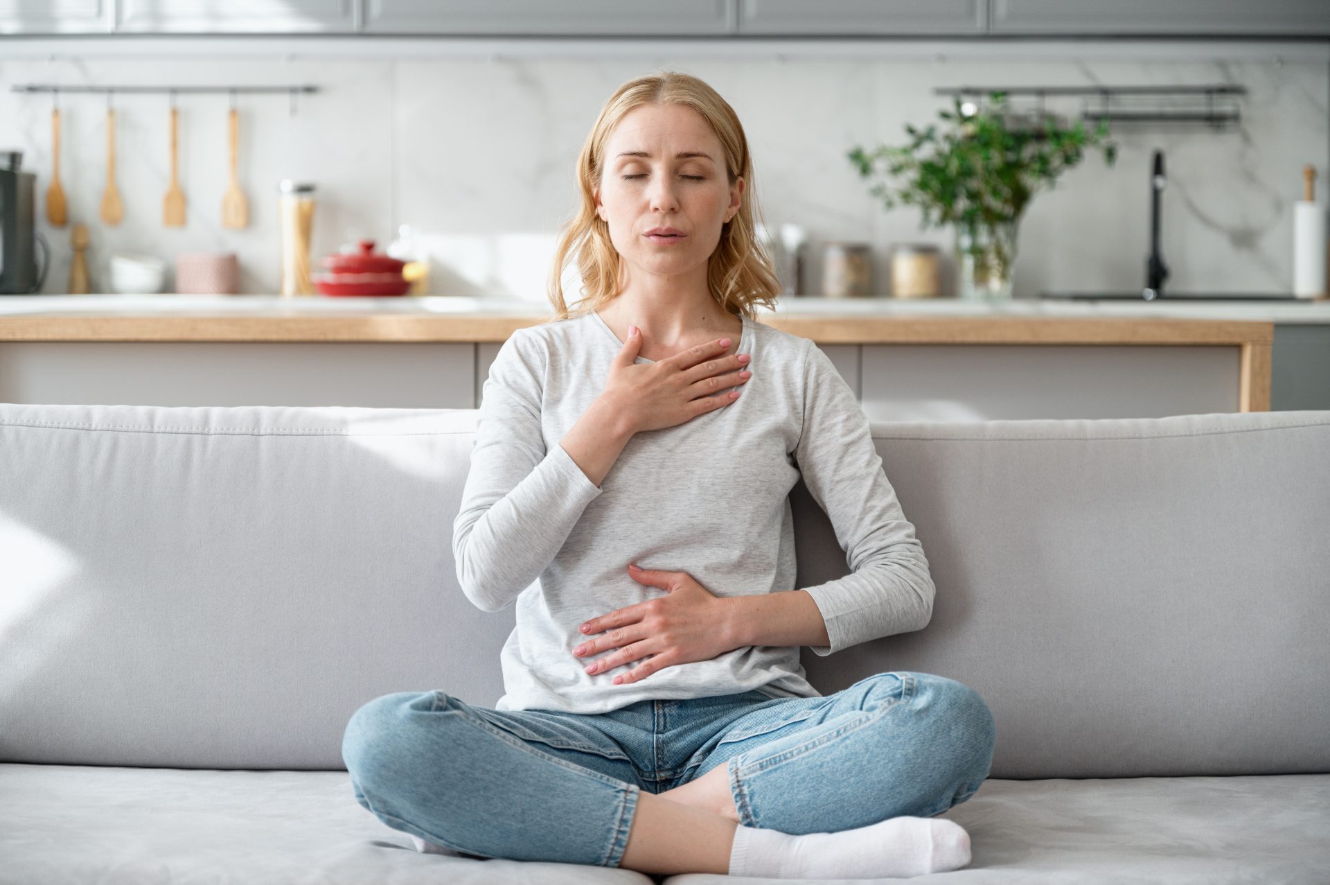 donna fa meditazione seduta sul divano