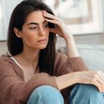 donna stressata con mano sulla fronte