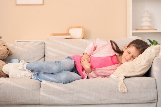 gastroenterite_cover bambina distesa sul divano con mal di stomaco