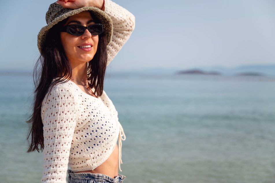protezione-occhi_cover giovane donna con occhiali da sole in spiaggia