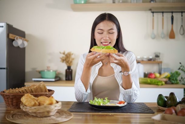 giovane donna mangia pane con avocado